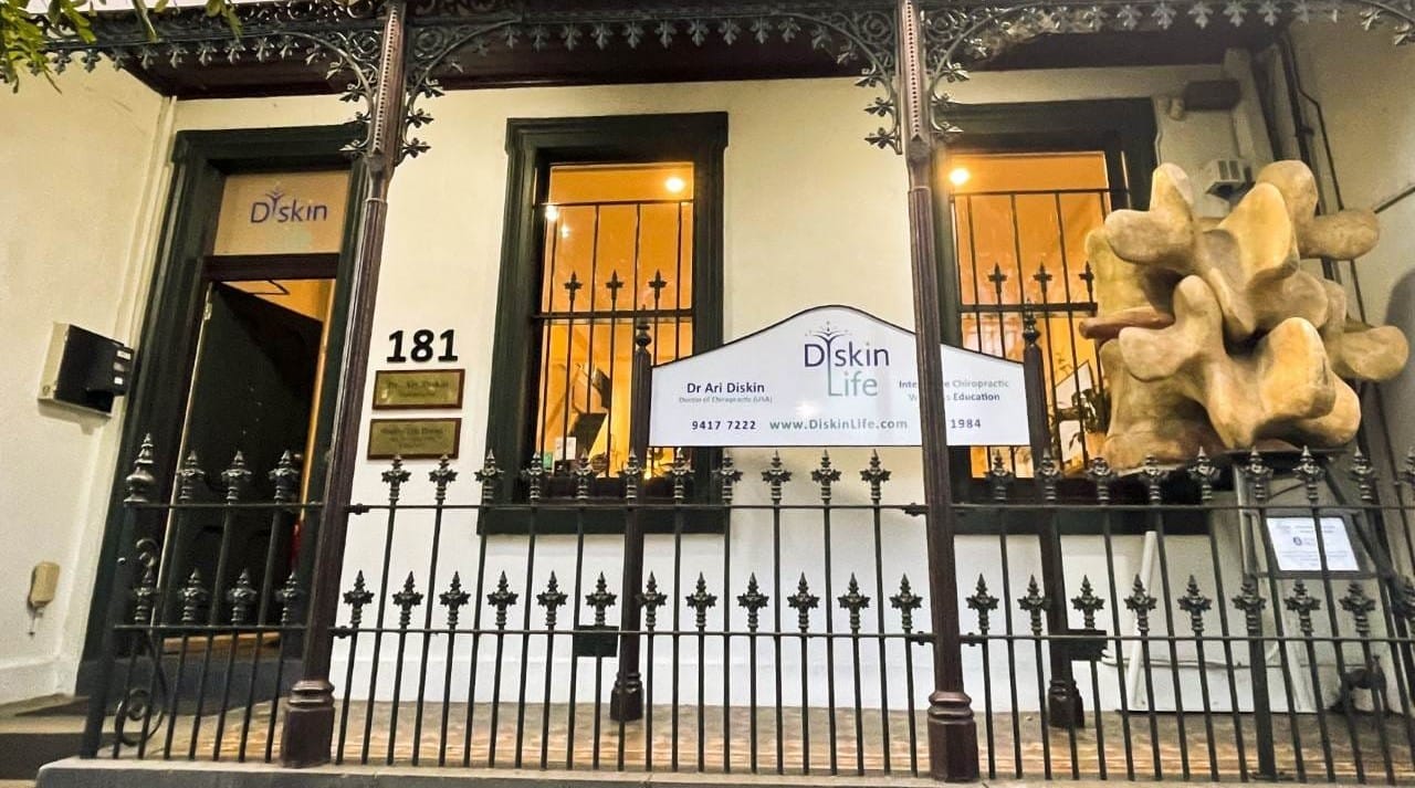The Diskin Life Centre – an 1862 Fitzroy building – with the world’s largest reproduction of human vertebrae standing at the entrance, lit warmly at dusk